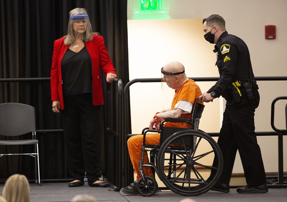 Joseph James DeAngelo, charged with being the Golden State Killer, is wheeled into the courtroom as his attorney, public defender Diane Howard, left, looks on in Sacramento, Calif., Monday June 29, 2020. DeAngelo, 74, pleaded guilty to multiple counts of murder and other charges 40 years after a sadistic series of assaults and slayings in California. Due to the large numbers of people attending, the hearing was held at a ballroom at California State University, Sacramento to allow for social distancing. (AP Photo/Rich Pedroncelli)