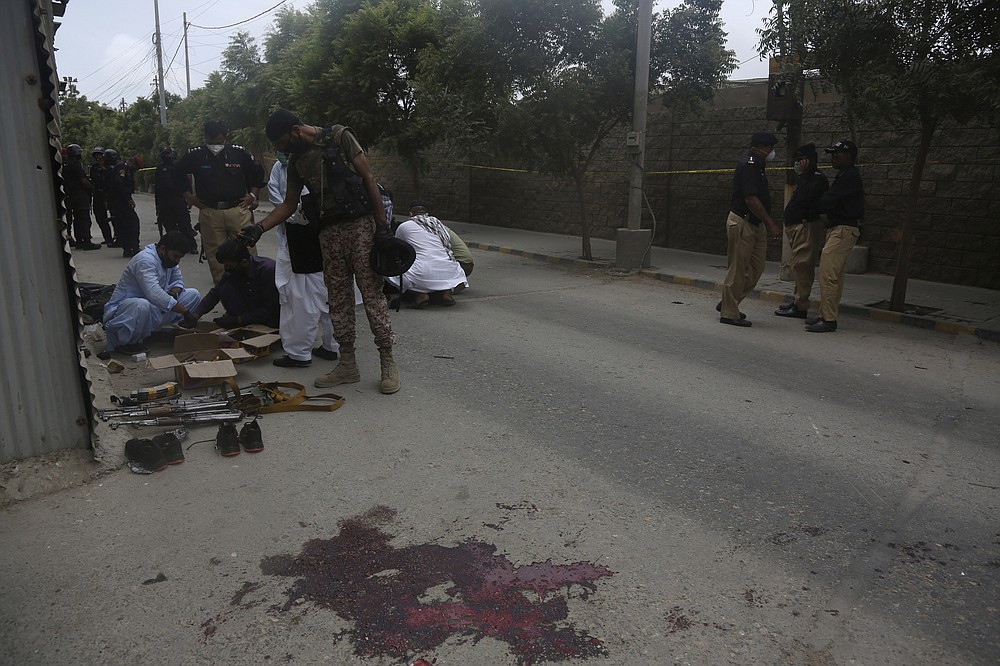 Security personnel examine confiscated ammunition from attackers outside the Stock Exchange Building in Karachi, Pakistan, Monday, June 29, 2020 after gunmen's attack. Special police forces deployed to the scene of the attack and in a swift operation secured the building. (AP Photo/Fareed Khan)
