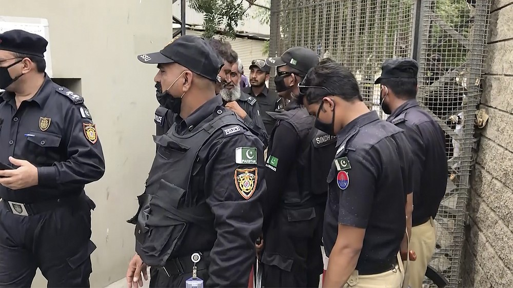 In this image made from a video, police stand around an entrance of stock exchange building in Karachi, Pakistan Monday, June 29, 2020. Militants attacked the stock exchange in the Pakistani city of Karachi on Monday, according to police. (AP Photo)