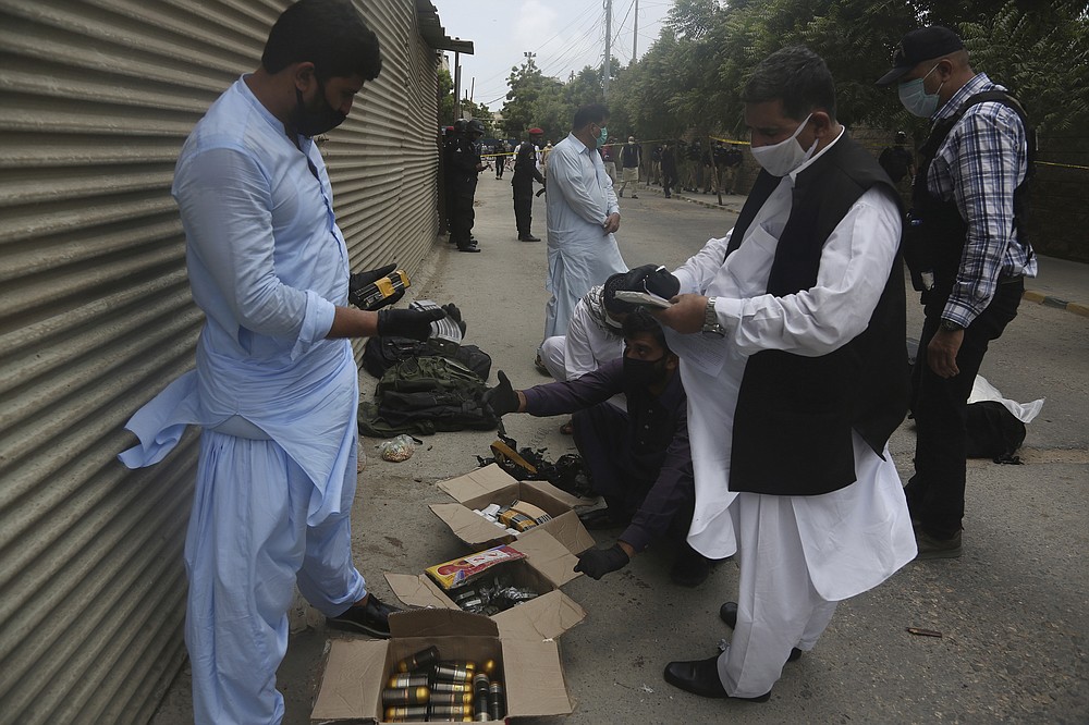 Security personnel examine confiscated ammunition from attackers outside the Stock Exchange Building in Karachi, Pakistan, Monday, June 29, 2020. Gunmen have attacked the stock exchange in the Pakistani city of Karachi on Monday. Special police forces deployed to the scene of the attack and in a swift operation secured the building. (AP Photo/Fareed Khan)