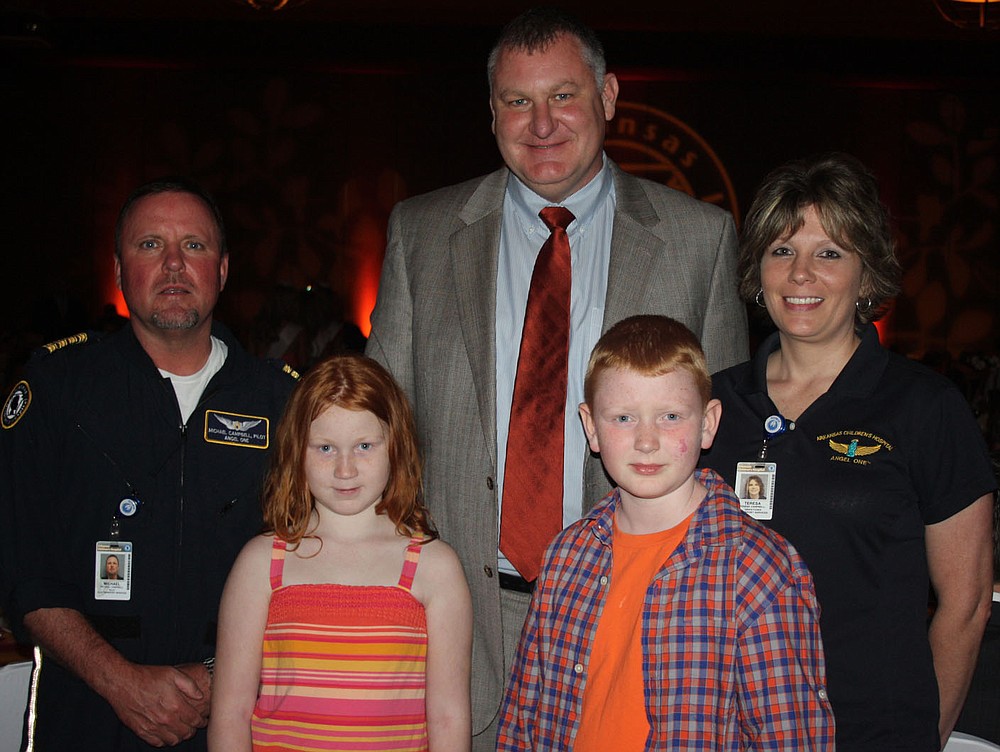 STAFF PHOTO CARIN SCHOPPMEYER Mike Campbell, Angel 1 pilot, from left, Jenna Wilson, David Wilson, Ethan Wilson and Teresa Campbell, Angel 1 dispatcher, attend the Color of Hope Gala to benefit Arkansas Children's Hospital on Aug. 24. Ethan was the 2013 Color of Hope Champion Child.