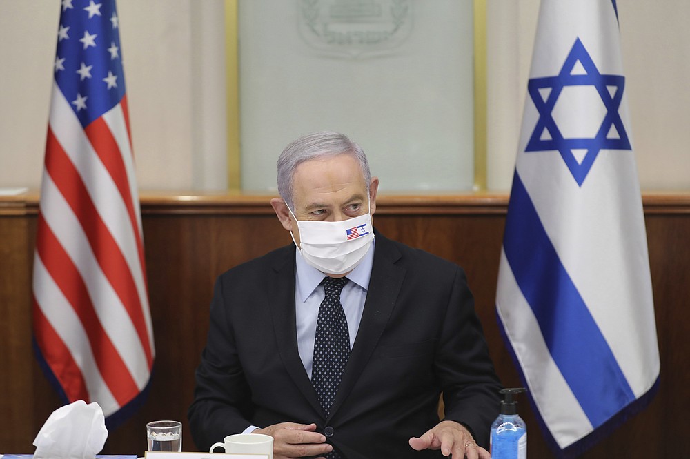 Israeli Prime Minister Benjamin Netanyahu attends a press briefing with US special envoy for Iran, Brian Hook, while wearing a face mask to help prevent the spread of the coronavirus, at the Prime Minister's office in Jerusalem, Tuesday June 30, 2020. (Abir Sultan/Pool via AP)