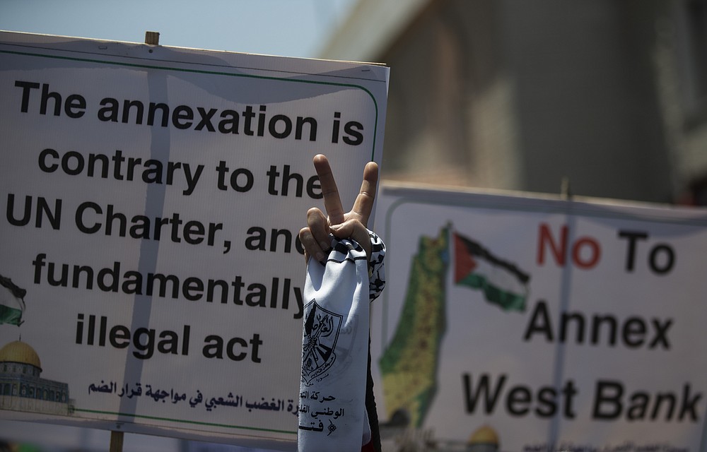A Palestinian woman flashes the victory sign as she demonstrates against Israeli plans for the annexation of parts of the West Bank, in Gaza City, Wednesday, July 1, 2020. (AP Photo/Khalil Hamra)