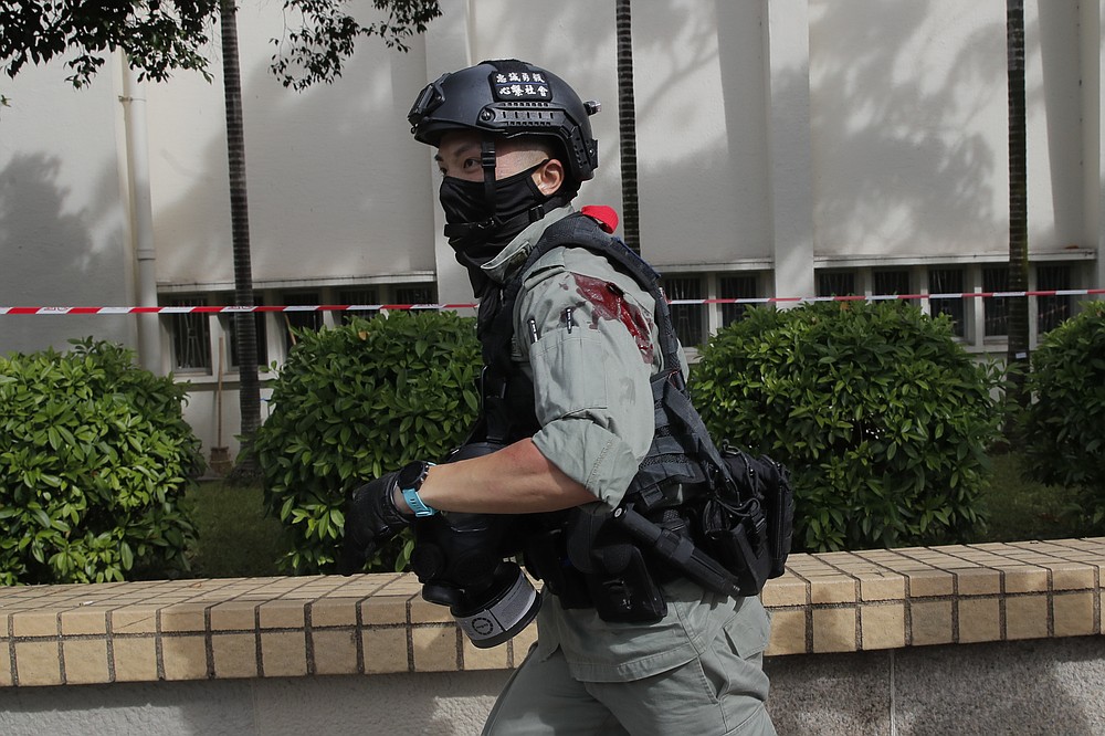 A police officer retreats after suffering injuries during a scuffle with protesters demonstrating  against the new security law during a march marking the anniversary of the Hong Kong handover from Britain to China, Wednesday, July. 1, 2020, in Hong Kong. Hong Kong marked the 23rd anniversary of its handover to China in 1997, and just one day after China enacted a national security law that cracks down on protests in the territory. (AP Photo/Kin Cheung)