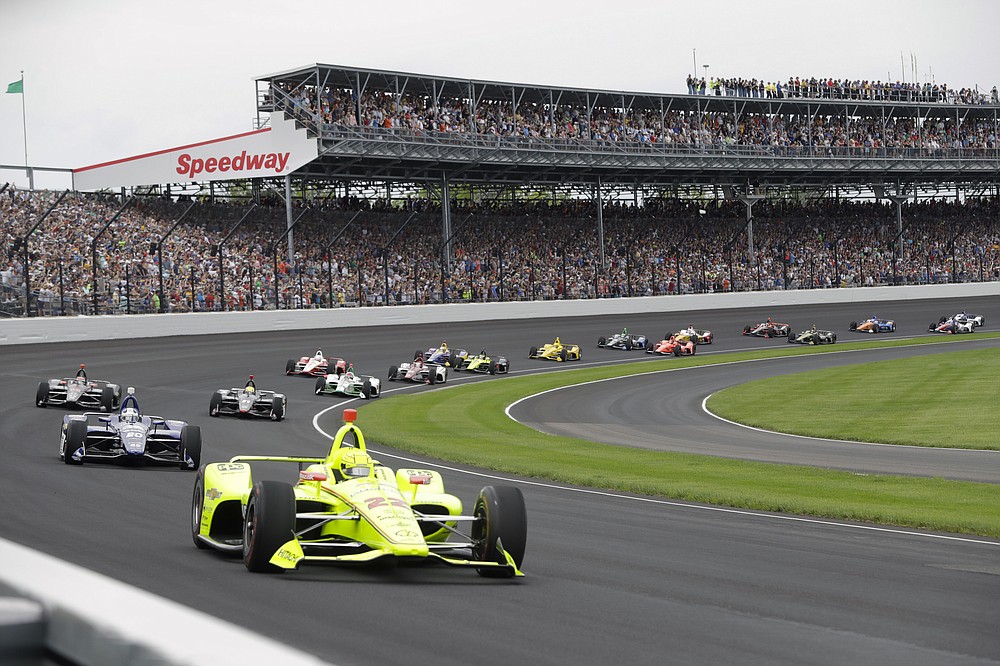 FILE - In this May 26, 2019, file photo, Simon Pagenaud, of France, leads the field through the first turn on the start of the Indianapolis 500 IndyCar auto race at Indianapolis Motor Speedway, in Indianapolis. The once frosty schism between the two biggest racing series in the United States has thawed and NASCAR's elite Cup Series will share a venue with IndyCar on the same weekend for the first time in history. (AP Photo/Darron Cummings, File)