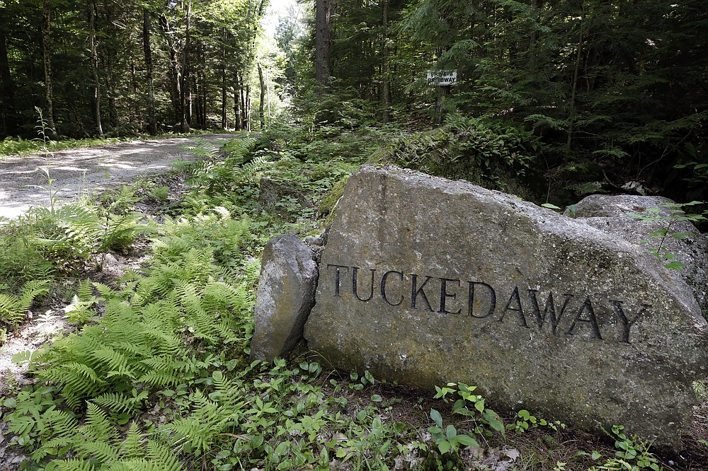 A boulder inscribed with "Tucked Away" sits beside a road going to an estate where Ghislaine Maxwell was taken into custody, Thursday, July 2, 2020, in Bradford, N.H. The British socialite faces charges she helped recruit three girls — one as young as 14 — to have sex with financier Jeffrey Epstein, who was accused of sexually assaulting dozens of girls and women over many years. (AP Photo/Steven Senne)