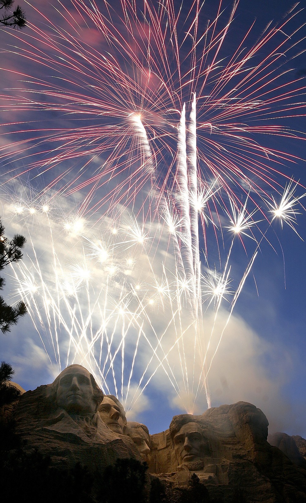 FILE - Fireworks light up the night sky over Mt. Rushmore National Memorial, S.D on Tuesday, July 3, 2007. When President Donald Trump speaks at the Mount Rushmore national memorial Friday, July 3, 2020, before the first fireworks show there in years, he'll stand before a crowd of thousands of people who won't be required to socially distance or wear masks despite the coronavirus pandemic. Public health experts say the lack of social distancing and enforced mask-wearing could lead to a surge in the disease, while the fireworks risk setting the surrounding forest ablaze. ( Seth A. McConnell/Rapid City Journal via AP, File)