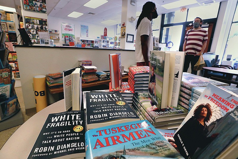 In this Wednesday, June 24, 2020, photograph, books are displayed, including "The Tuskegee Airmen," and "White Fragility," at the Black-owned Frugal Bookstore in the Roxbury neighborhood of Boston. Many from outside Boston have recently shopped and supported the store amid nationwide protests against racism. (AP Photo/Charles Krupa)