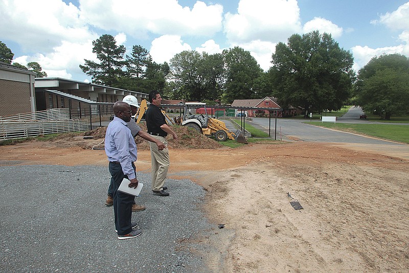 Pine Bluff School District Chief Operating Officer Leroy Harris (front to back), East Harding Construction Site Supervisor Carl Banks and East Harding Construction Director of Business Development Win Trafford look over an area at Southwood Elementary School where concrete trucks will stage for a concrete pour to test the ability of the surrounding ground to bear weight.
(Arkansas Democrat-Gazette/Dale Ellis)