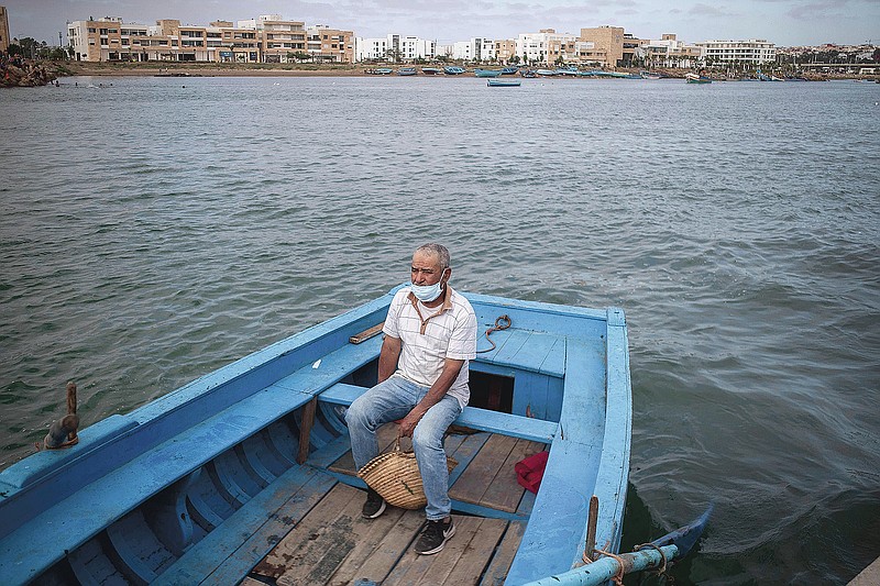 A man crosses by boat from Rabat to Sale after lockdown measures were lifted, in Morocco, Friday, June 26, 2020. Moroccans are re-experiencing a taste of the life before. In newly opened public spaces, every sip of coffee in a cafe, every dip in a river with friends, every moment of outdoor intimacy is savored, marking the end of more than three months of lockdown. (AP Photo/Mosa'ab Elshamy)