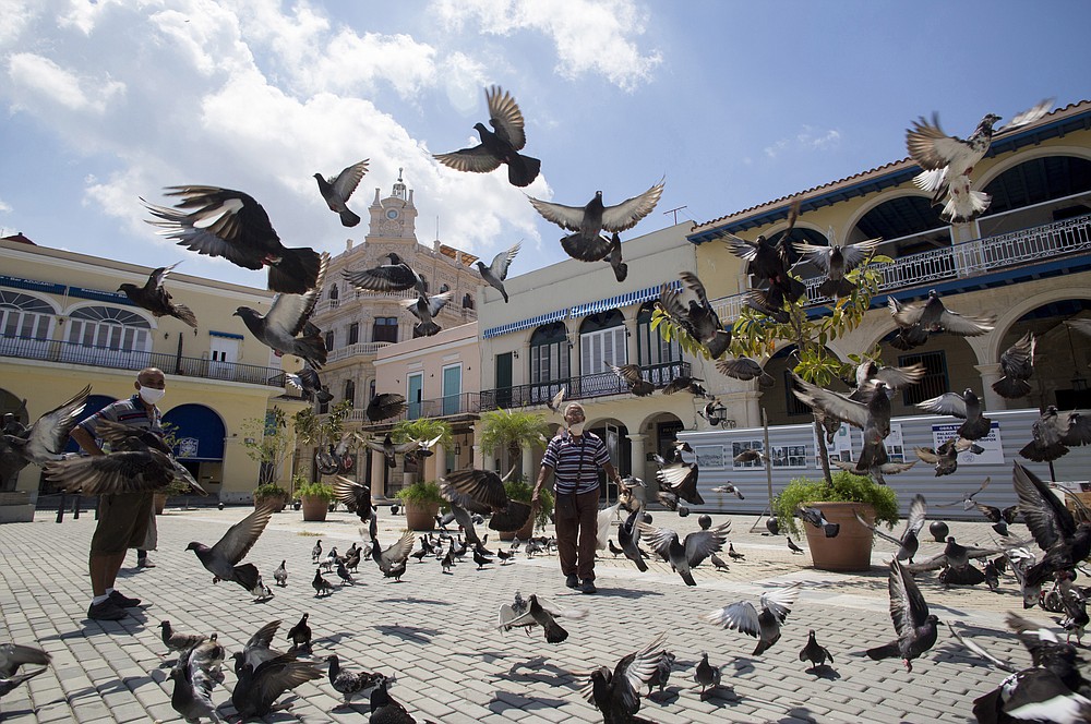 Pigeons take flight in an empty Plaza Vieja in Havana, Cuba, Tuesday, June 23, 2020. Nearly three months of a near-total shutdown of commerce, transportation, and public spaces, combined with health monitoring and virus testing has led to the virtual elimination of COVID-19 in Cuba. (AP Photo/Ismael Francisco)