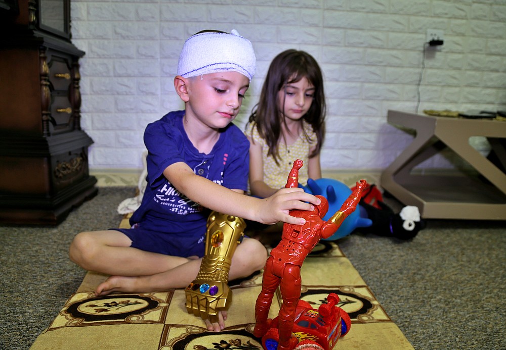 Henisha Kaywan, 7, right, and her brother Hezhwan Kaywan, 6, injured in a Turkish Army bombing, play in their home in the city of Sulaimaniyah, northern Iraq on July 1, 2020. Iraq has set up border posts to prevent a Turkish military advance deeper into Iraqi territory this week as civilians suffer from over two weeks of airstrikes as Ankara continues to target Kurdish rebels in the country's north. (AP Photo/Adnan Ahmed)