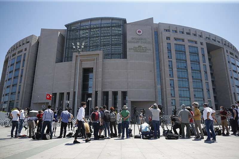 Members of the media, work outside a court in Istanbul, Friday, July 3, 2020, where the trial in absentia of two former aides of Saudi Crown Prince Mohammed bin Salman and 18 other Saudi nationals over the 2018 killing of Saudi journalist Jamal Kashoggi had began. Turkish prosecutors have indicted the 20 Saudi nationals over Khashoggi's grisly killing at the Saudi Consulate in Istanbul that cast a cloud of suspicion over Prince Mohammed and are seeking life prison terms for defendants who have all left Turkey. Saudi Arabia rejected Turkish demands for the suspects' extradition and put them on trial in Riyadh.(AP Photo/Emrah Gurel)