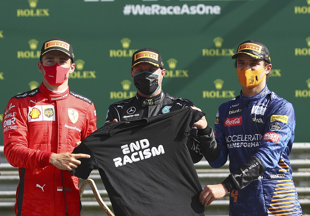 Race winner Mercedes driver Valtteri Bottas of Finland, centre, pose with second placed Ferrari driver Charles Leclerc of Monaco, left, and third placed Mclaren driver Lando Norris of Britain after the Austrian Formula One Grand Prix at the Red Bull Ring racetrack in Spielberg, Austria, Sunday, July 5, 2020. (Mark Thompson/Pool via AP)