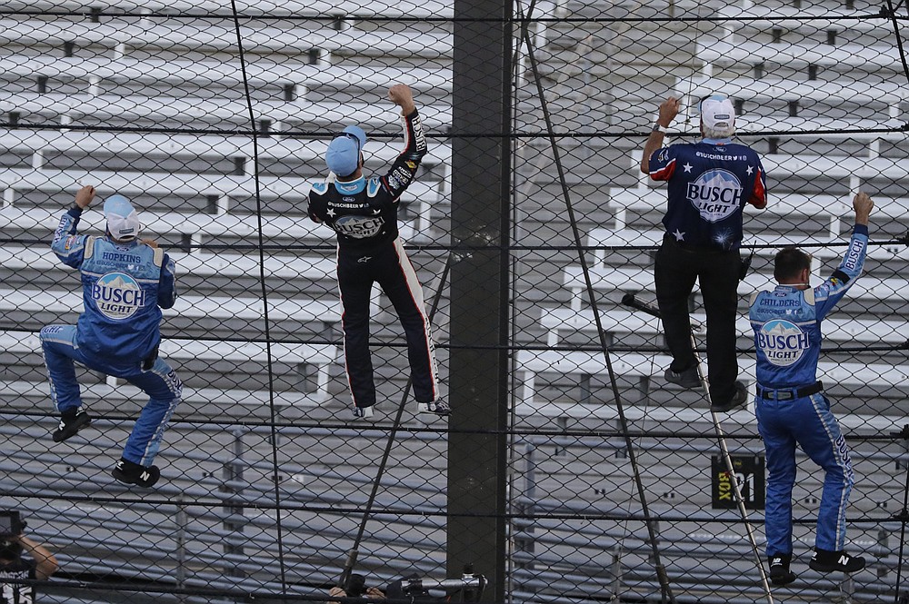 Kevin Harvick, second from left, and some members of the team's crew climb the fence after Harvick won the NASCAR Cup Series auto race at Indianapolis Motor Speedway in Indianapolis, Sunday, July 5, 2020. (AP Photo/Darron Cummings)