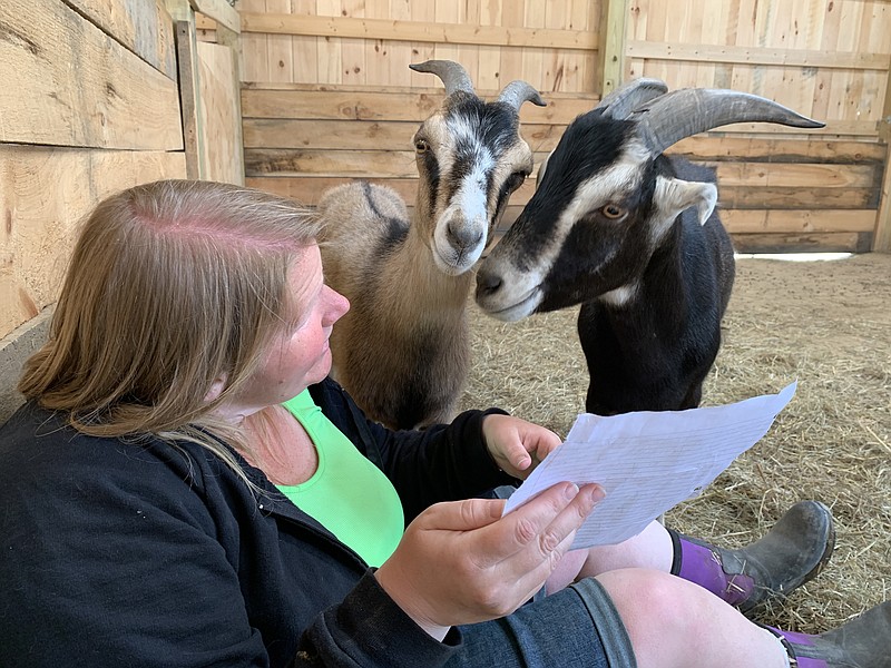 Sarah Thorton, Indraloka Animal Sanctuary's director of education, reads pen pal letters to goats Bapu and Madalista. Kids can write to an animal at the sanctuary and get a response from the animal (with a human's help). (The Washington Post/Johnny Braz)