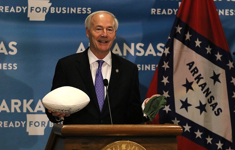 Thomas Methe/Arkansas Democrat-Gazette
Gov. Asa Hutchinson holds up a football and a facemask during the daily covid-19 briefing on Wednesday, July 1, 2020, at the state Capitol in Little Rock. "If you want to see this (football) in the fall you have to be wearing of these right now (facemask)," the governor said masks need to be worn in order to curb the spread of covid-19 if there was a chance of football being played in the fall at any level.