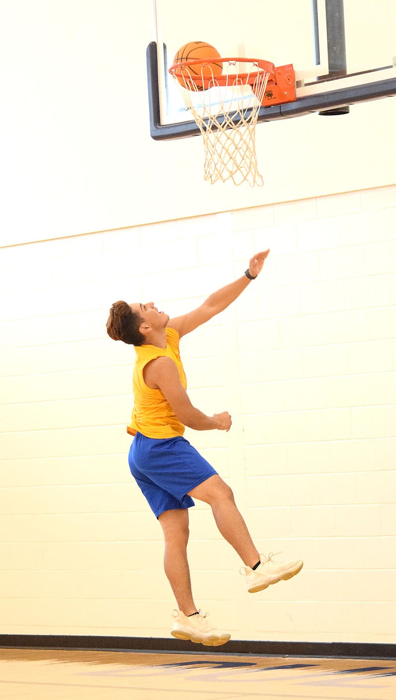 Westside Eagle Observer/MIKE ECKELS

Andres Revolorio hits a reverse layup during the Decatur Bulldog afternoon practice session with new head basketball coach Dayton Shaw July 7 in the middle school gym in Decatur. It is unclear whether any high school sports will take place this school year but Shaw wants his team to be ready just in case..