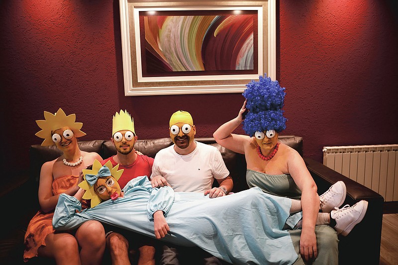 The Arevalo-Robledo family, dressed as The Simpsons, poses for a photo in their living room during a government-ordered lockdown to curb the spread of the new coronavirus in Buenos Aires, Argentina, Saturday, June 27, 2020. Mariano Arevalo is Homer, Mariel Robledo is Marge, Federico Garozzo is Bart, Julieta is Lisa and Camila Arevalo is Maggie. This family said every day of lockdown started to look the same, so they decided every Saturday to dress in different costumes to combat boredom and put some humor into their lives. (AP Photo/Natacha Pisarenko)