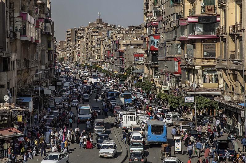 FILE - In this April 14, 2020 file photo, people crowd a street a few hours ahead of curfew in Cairo, Egypt. As Egyptian authorities fight the swelling coronavirus outbreak, security agencies have tried to stifle criticism about the handling of the health crisis by the government of President Abdel Fattah el-Sissi. (AP Photo/Nariman El-Mofty, File)