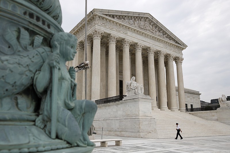 A police officer walks outside the Supreme Court on Capitol Hill in Washington, Monday, July 6, 2020. (AP Photo/Patrick Semansky)