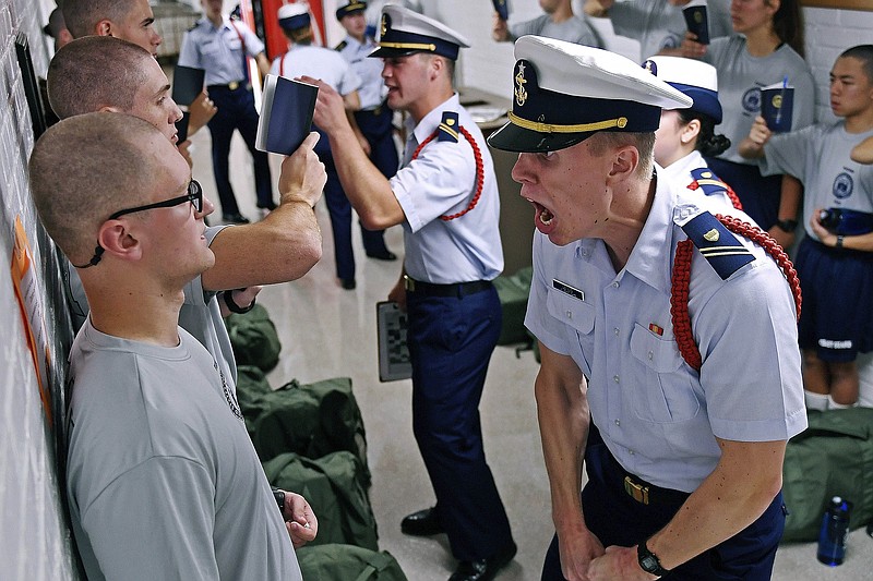 FILE - In this July 1, 2019, file photo, Whisky 2 company Cadre Jacob Denns, right, shouts instructions to swab Nicolas Fisher, left, of Pelham, N.H., on the first day of a seven-week indoctrination to military academy life for the Class of 2023 at the U.S. Coast Guard Academy in New London, Conn. The school, like other service academies and military training centers, has made major changes because of the coronavirus pandemic. That means the eight weeks of boot camp for new cadets, known as "Swab Summer," will be much different. There will be no haircuts, no drilling, no running as a group from place to place, no lining up against the wall in the hall of the barracks for pushups. (Sean D. Elliot/The Day via AP, File)