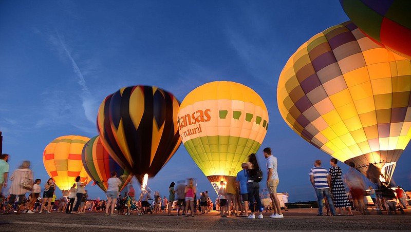 NWA Democrat-Gazette/ANDY SHUPE
Visitors watch Saturday, Aug. 24, 2019, as hot air balloons glow during the inaugural Soar NWA at Drake Field in Fayetteville. The event features hot air balloons, helicopter rides, live music, food and vendors to benefit Open Avenues.