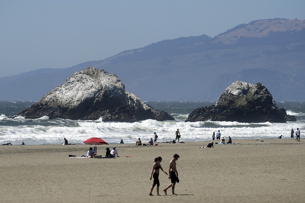 People visit Ocean Beach during the coronavirus outbreak in San Francisco, Sunday, July 5, 2020. Californians mostly heeded warnings to stay away from beaches and other public spaces during the long weekend as state officials urged social distancing amid a spike in coronavirus infections and hospitalizations. (AP Photo/Jeff Chiu)
