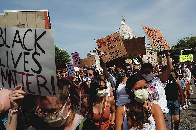 FILE - In this May 31, 2020, file photo, protesters march away from the State Capitol, in St. Paul, Minn. A loose network of Facebook groups that took root across the country in April to organize protests over coronavirus stay-at-home orders has become a hub of misinformation and conspiracies theories that have pivoted to a variety of new targets. Their latest: Black Lives Matter and the nationwide protests against racial injustice. (AP Photo/John Minchillo, File)