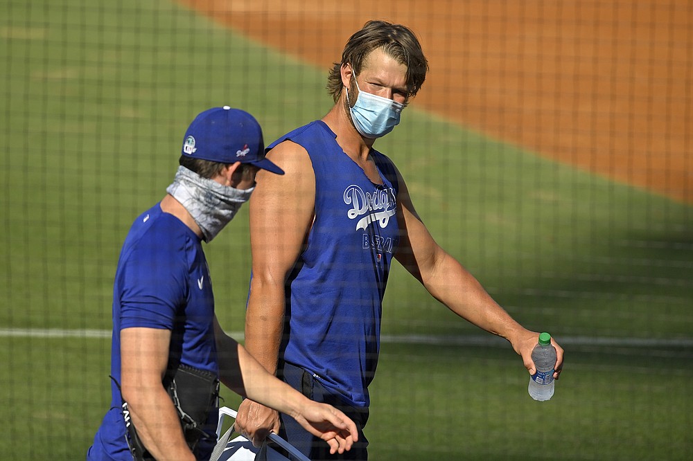 Los Angeles Dodgers starting pitcher Clayton Kershaw, right, talks with starting pitcher Walker Buehler during the restart of baseball spring training Sunday, July 5, 2020, in Los Angeles. (AP Photo/Mark J. Terrill)