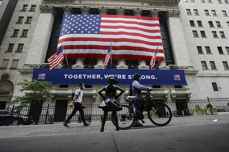 FILE - In this Tuesday, July 7, 2020 file photo, pedestrians wearing protective masks during the coronavirus pandemic pass by the New York Stock Exchange in New York. (AP Photo/Frank Franklin II, File)