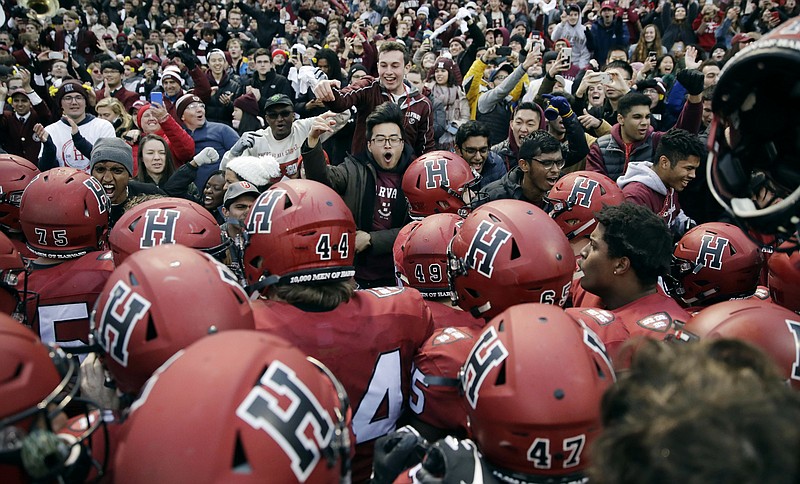 FILE - In this Nov. 17, 2018, file photo, Harvard players, students and fans celebrate their 45-27 win over Yale after an NCAA college football game at Fenway Park in Boston. Harvard defeated Yale. The Ivy League has canceled all fall sports because of the coronavirus pandemic. (AP Photo/Charles Krupa, File)