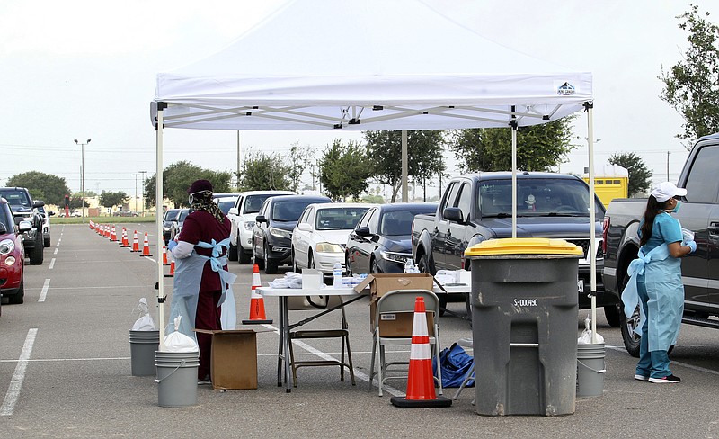 Health officials and members of the military assist during COVID-19 testing on Wednesday at HEB Park in Edinburg, Texas. - Delcia Lopez/The Monitor via AP