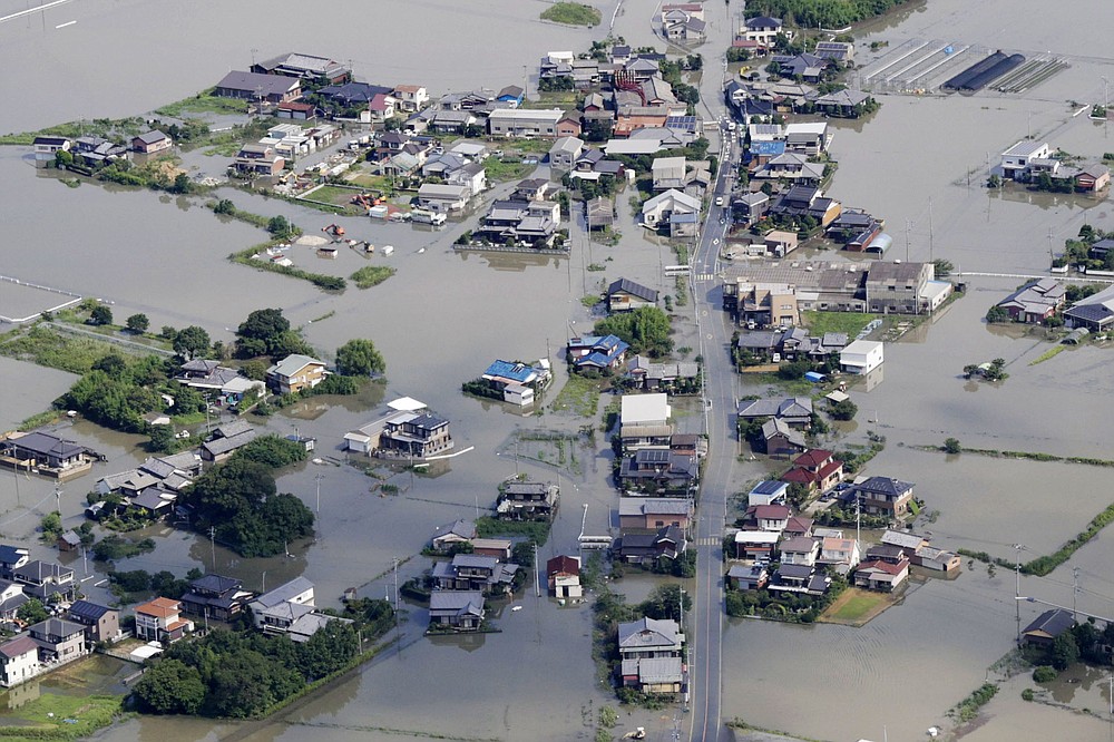 This aerial photo shows the flooded area caused by the swollen Chikugo River, not seen in photo, in Kurume city, Fukuoka prefecture, southern Japan Wednesday, July 8, 2020. Pounding rain that already caused deadly floods in southern Japan was moving northeast Wednesday, battering large areas of Japan's main island, swelling more rivers, triggering mudslides and destroying houses and roads. (Kyodo News via AP)