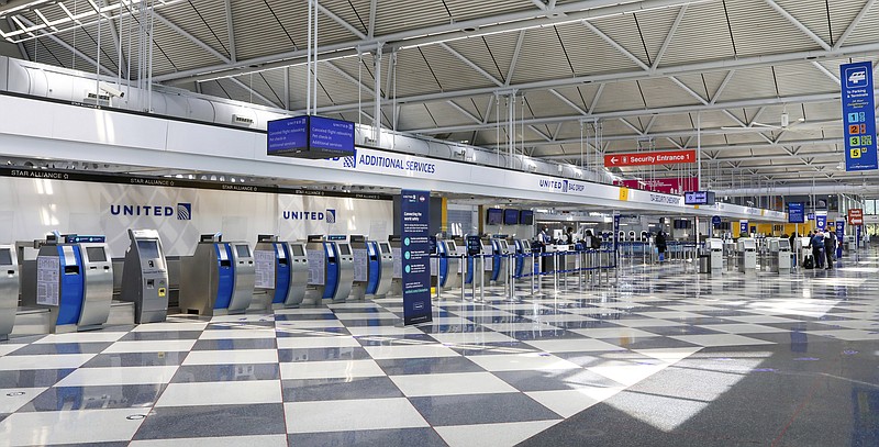 Rows of United Airlines check-in counters at O'Hare International Airport in Chicago are unoccupied on June 25 amid the coronavirus pandemic. United is sending layoff warnings to 36,000 employees, nearly half its U.S. staff, the airline announced Wednesday. - AP Photo/Teresa Crawford