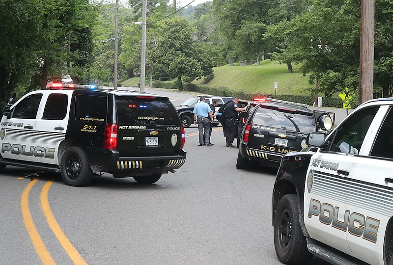 Hot Springs police work the scene in the 700 block of Spring Street Thursday where Payton Mann, 18, was arrested shortly after 11 a.m. on a capital murder charge for the March 14 shooting death of Joshua Severns, 20, of Hot Springs. - Photo by Richard Rasmussen of The Sentinel-Record