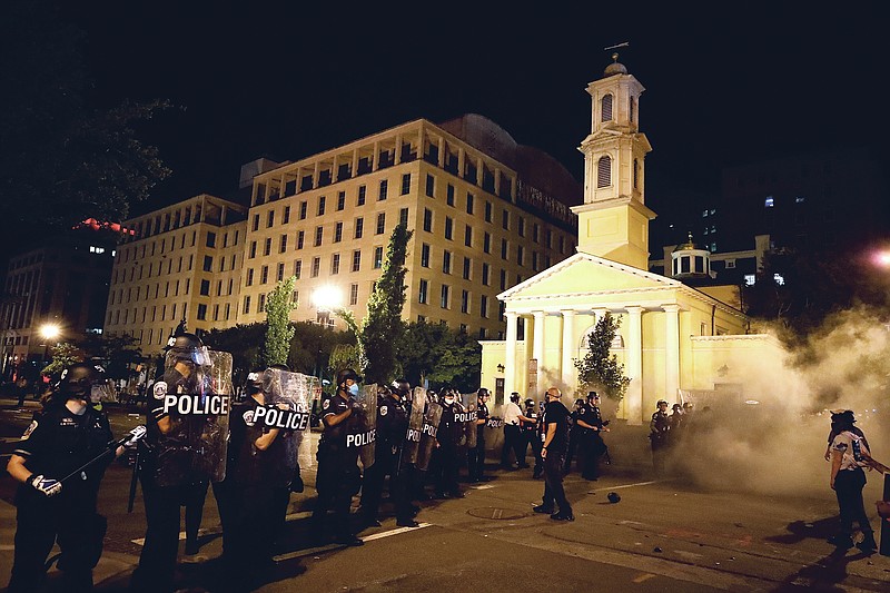 FILE - In this Saturday, May 30, 2020 file photo, police for a line near St. John's Episcopal Church as demonstrators gather to protest the death of George Floyd, near the White House in Washington. Floyd, a Black man, died after being restrained by Minneapolis police officers. St. John's, at the epicenter of protests in Washington, has a long legacy on civil rights dating to its embrace of the 1963 March on Washington. (AP Photo/Alex Brandon)