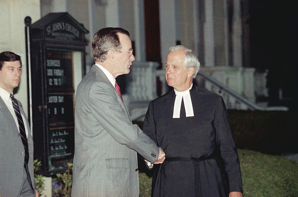 FILE - In this April 13, 1990 file photo, President George Bush is escorted by Rector John Harper, of St. John's Episcopal Church, following early morning Good Friday services in Washington. (AP Photo/Marcy Nighswander)