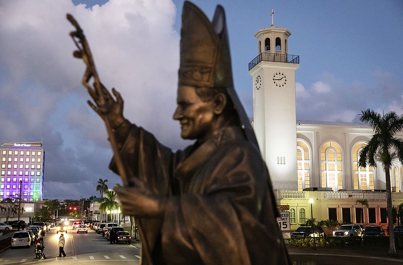 FILE - In this Tuesday, May 7, 2019 file photo, a statue of Pope John Paul II stands outside the island's main cathedral, Dulce Nombre de Maria Cathedral-Basilica, during a Mass in Hagatna, Guam. Over 200 clergy abuse lawsuits led church leaders in the U.S. territory to seek bankruptcy protection, as they estimated at least $45 million in liabilities. Even so, the Archdiocese of Agana’s parishes, schools and other organizations have received at least $1.7 million in coronavirus rescue funds in 2020, as it sues the Small Business Administration for approval to get a loan for its headquarters, according to the archdiocese’s bankruptcy filing. (AP Photo/David Goldman)