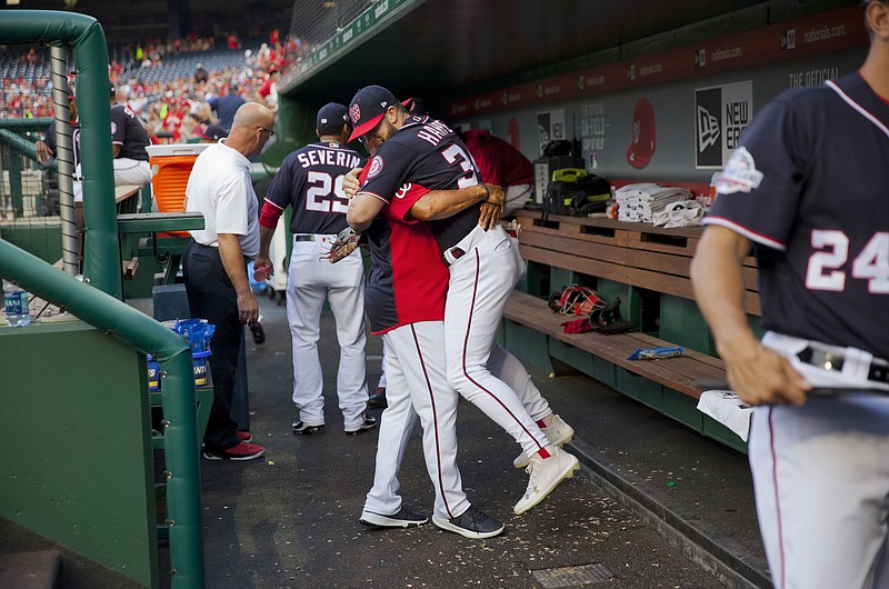 Washington Nationals Bryce Harper is hugged and lifted off the ground by his manager Dave Martinez in the dugout prior to the start of a May 4, 2018, baseball game against the Philadelphia Phillies at Nationals Park in Washington. High fives and fist bumps are out. Hugs are a no-go. And just like crying, there's no spitting in baseball, at least for now. Things sure will be different when it's time to play ball in two weeks. - Photo by Pablo Martinez Monsivais of The Associated Press