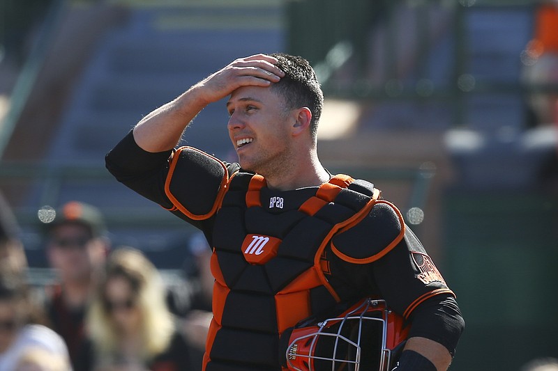 FILE - In this Monday, Feb. 24, 2020, file photo, San Francisco Giants catcher Buster Posey wipes sweat from his forehead during the first inning of a spring training baseball game against the Arizona Diamondbacks in Scottsdale, Ariz. Posey is the latest big-name player to skip this season because of concerns over the coronavirus pandemic. Posey announced his decision on Friday, July 10, 2020. He says his family finalized the adoption of identical twin girls this week. The babies were born prematurely and Posey said after consultations with his wife and doctor he decided to opt out of the season. (AP Photo/Ross D. Franklin, File)