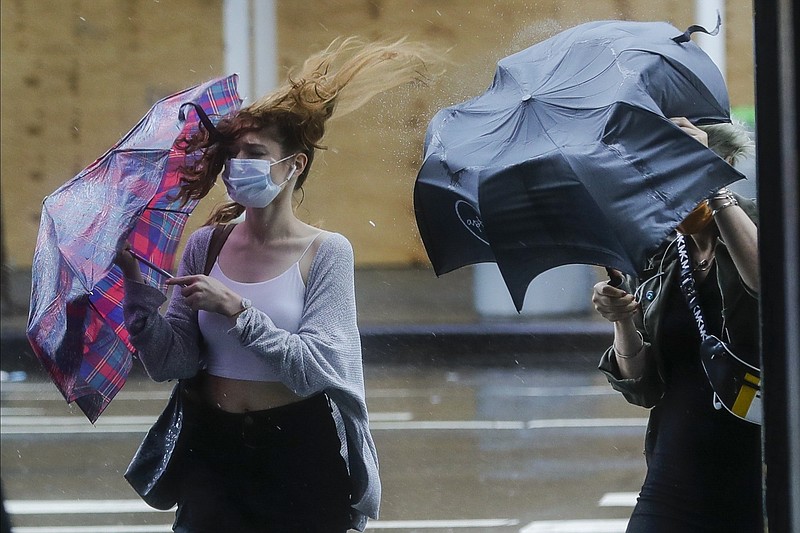 Pedestrians struggle to control their umbrellas due to inclement weather brought about by Tropical Storm Fay, Friday, July 10, 2020, in New York. Beaches closed in Delaware and rain lashed the New Jersey shore as fast-moving Tropical Storm Fay churned north on a path expected to soak the New York City region. (AP Photo/Frank Franklin II)