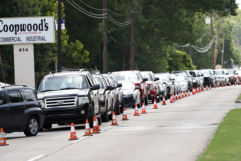 People wait inside their vehicles in line at COVID-19 testing site Wednesday, July 8, 2020, in Houston. (AP Photo/David J. Phillip)