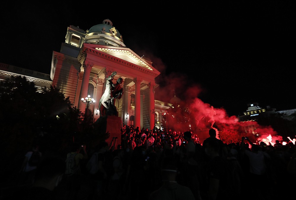 Protesters clash with riot police on the steps of the Serbian parliament during a protest in Belgrade, Serbia, Friday, July 10 2020. Serbia's President Aleksandar Vucic said Friday he's not worried about losing political power amid large protests against his handling of the coronavirus crisis and hard-line rule, but instead expressed his fear about the spread of the virus by the demonstrators. The spontaneous protests started on Tuesday when Vucic announced that Belgrade would be placed under a new three-day lockdown following a second wave of confirmed coronavirus infections. (AP Photo/Darko Vojinovic)