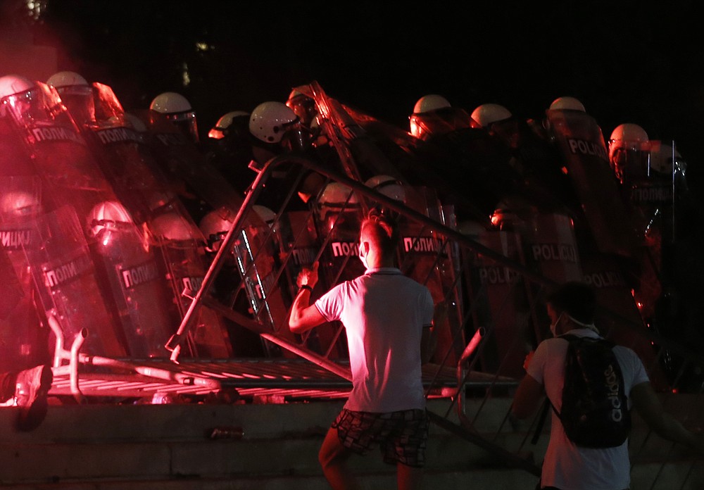 Protesters clash with riot police on the steps of the Serbian parliament during a protest in Belgrade, Serbia, Friday, July 10 2020. Serbia's President Aleksandar Vucic said Friday he's not worried about losing political power amid large protests against his handling of the coronavirus crisis and hard-line rule, but instead expressed his fear about the spread of the virus by the demonstrators. The spontaneous protests started on Tuesday when Vucic announced that Belgrade would be placed under a new three-day lockdown following a second wave of confirmed coronavirus infections. (AP Photo/Darko Vojinovic)