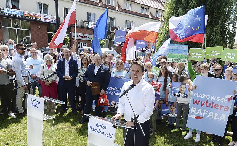 In this Thursday, July 9, 2020 photo Rafal Trzaskowski, front, contender in Poland's tight presidential election runoff on Sunday, July 12, 2020, speaks to supporters during a rally in Raciaz, Poland. Trzaskowski is running against incumbent conservative president, Andrzej Duda, who has backing from the ruling party. Opinion polls suggest the election may be decided by a small number of votes. (AP Photo/Czarek Sokolowski)