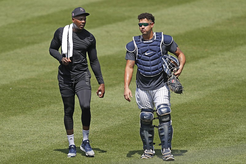 New York Yankees relief pitcher Aroldis Chapman, left, leaves the field after a bullpen session with catcher Gary Sanchez after a bullpen session during a baseball summer training camp workout Sunday, July 5, 2020, at Yankee Stadium in New York. (AP Photo/Kathy Willens)