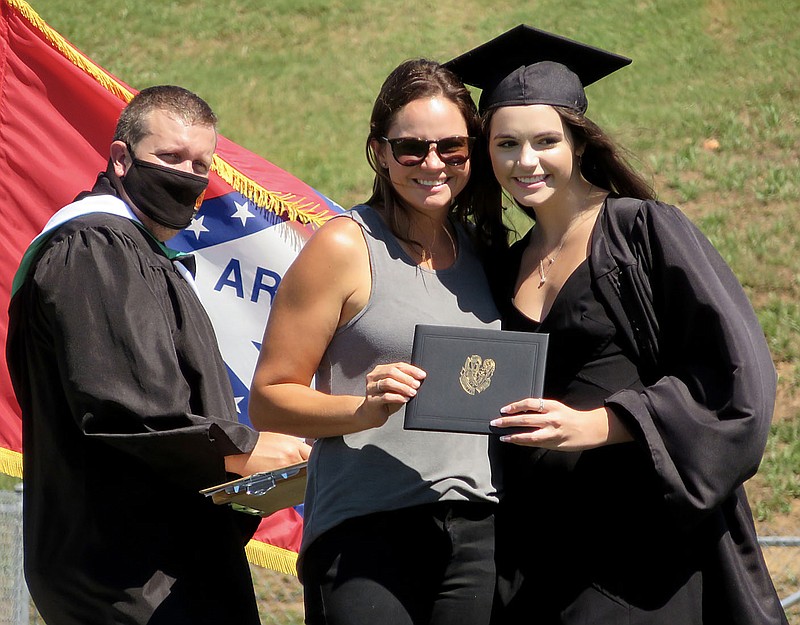 Westside Eagle Observer/RANDY MOLL
After their names were called by assistant principal Taos Jones, Gravette students picked up their diplomas and stopped for a photo with a parent or guardian on Sunday afternoon in Lion Stadium. Kharli Furlow poses with her mother after receiving her diploma.