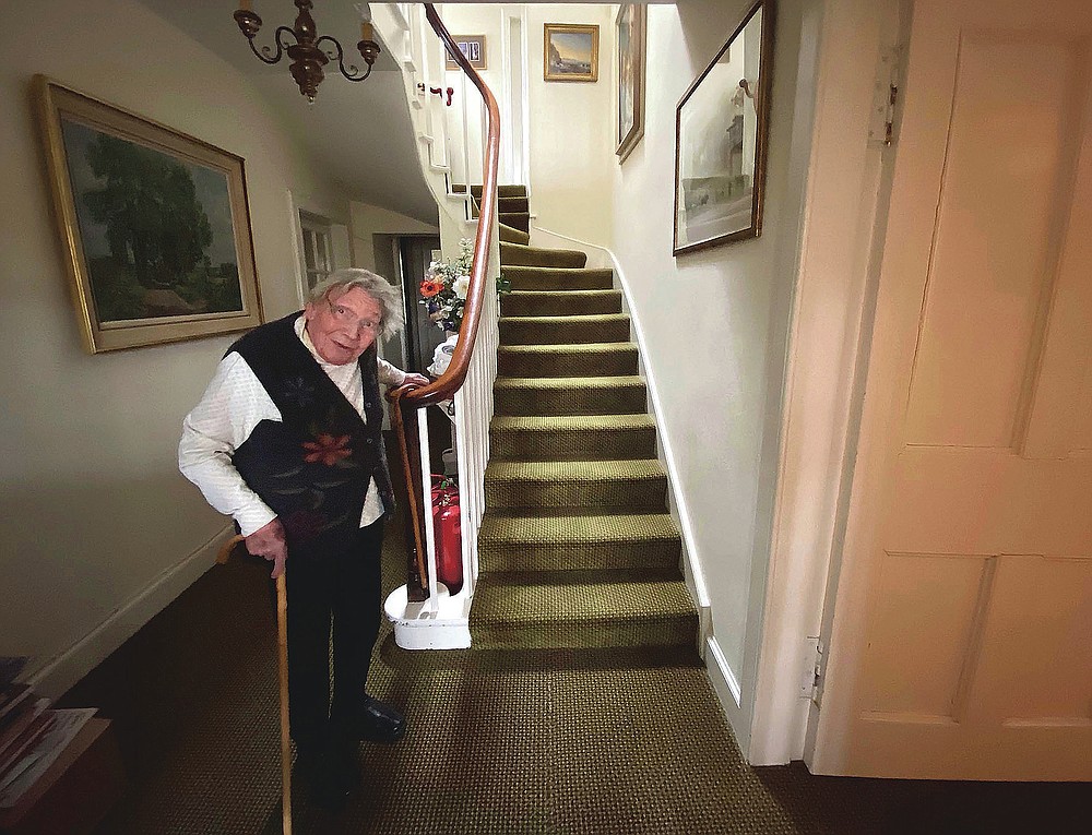 In this undated family handout, Margaret Payne poses for a photo on the stairs of her home in Sutherland, Scotland. Payne, the 90-year-old grandmother who launched an epic climb to raise money for charity completed her fundraiser Tuesday, June 23, 2020 scaling her home’s stairs the equivalent of 731 meters (2,398 feet). That's enough to reach the top of the iconic Scottish peak, Suilven. The feat took her 73 days and kept her busy for 10 weeks while the nation sheltered in lockdown due to the COVID-19 pandemic. (Payne Family via AP)