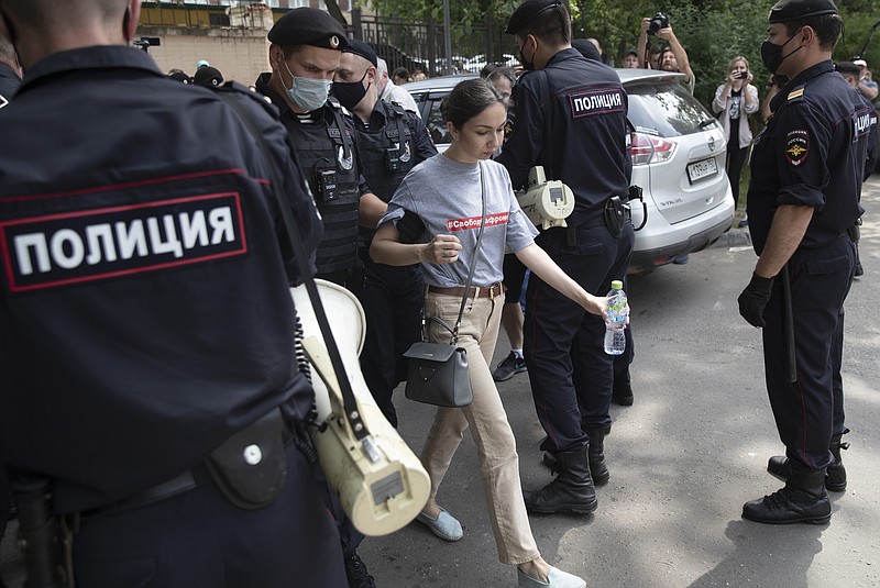 Police officers detain a protester during a rally to support Ivan Safronov near the Lefortovo prison in Moscow, Russia, Monday, July 13, 2020. Safronov, an ex-journalist who worked as an adviser to the director of Russia's state space corporation has been arrested and jailed on charges of passing military secrets to Czech intelligence. Ivan Safronov wrote about military and security issues before becoming an adviser to the head of Roscosmos. (AP Photo/Pavel Golovkin)